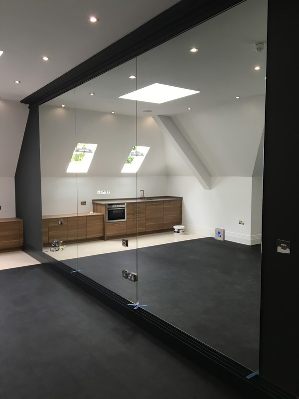 Frameless glass partition in loft conversion by Milton Keynes glaziers