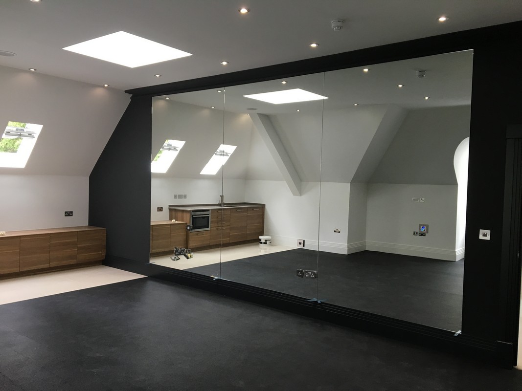 Frameless glass wall dividing loft conversion in Milton Keynes